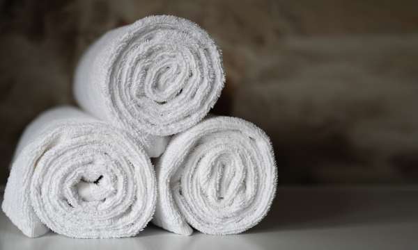 3 white rolled up towels